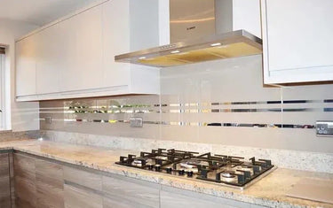 Modern kitchen with sleek glass splashback, granite countertop, and stainless steel hob