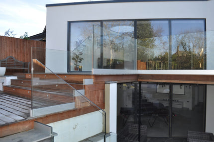 Frameless glass balustrade on a garden terrace at a modern home, installed by CreoGlass