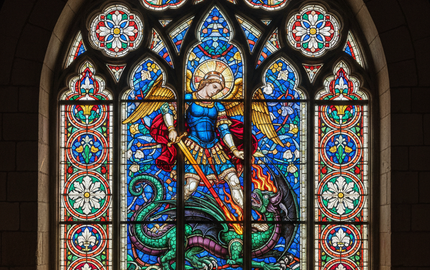 Bespoke stained glass window featuring angel and dragon, intricate decorative glass design for architectural use