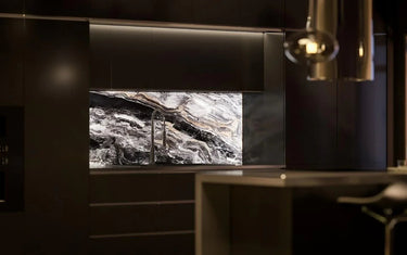 Luxury kitchen with marble-effect glass splashback, modern black cabinets, and under-cabinet lighting