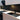 Sleek black glass splashback in modern kitchen with white cabinets and black sink