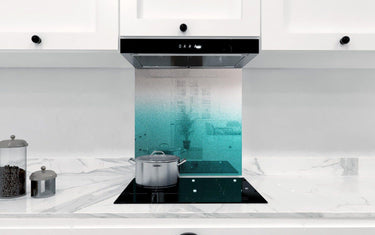 Teal ombre glass kitchen splashback with marble countertop and induction hob