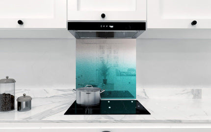 Teal ombre glass kitchen splashback with marble countertop and induction hob