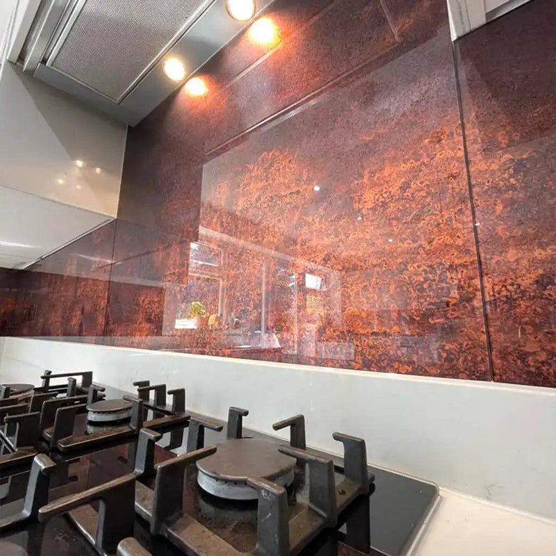 Luxury kitchen with bespoke decorative glass backsplash featuring warm amber tones and reflective finish