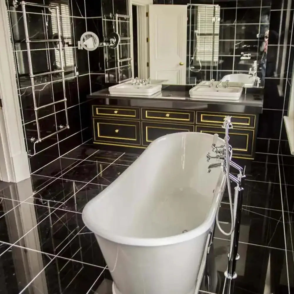 Luxury bathroom with black tiled walls and floor, freestanding tub, and mirrored vanity