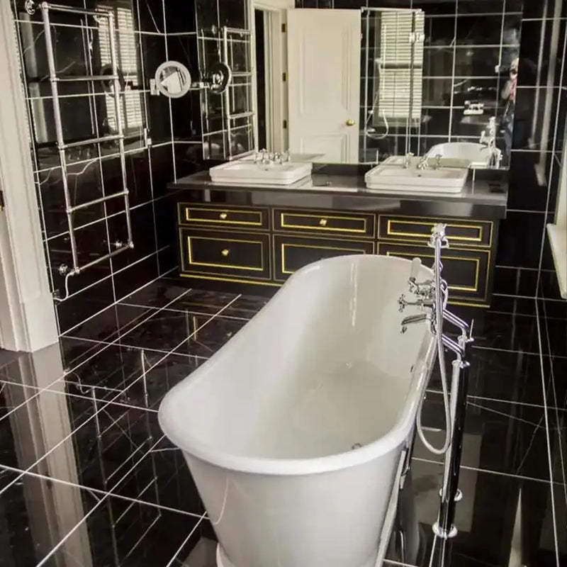 Luxury bathroom with black tiled walls and floor, freestanding tub, and mirrored vanity