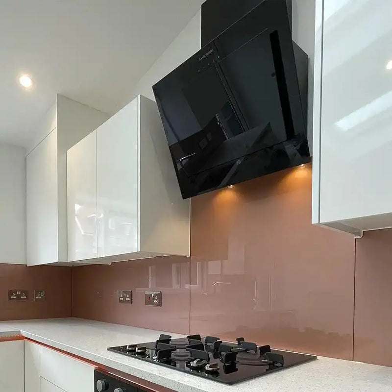 Copper-tinted glass kitchen splashback with modern white cabinets and black range hood