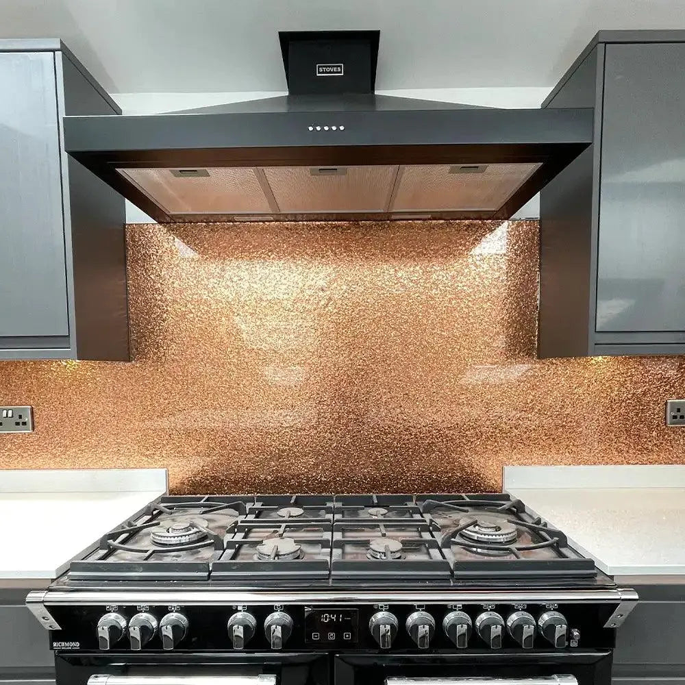 Copper textured glass splashback in modern kitchen with black range cooker and extractor hood