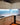 Modern kitchen with LED backlit blue glass splashback and sleek white cabinets