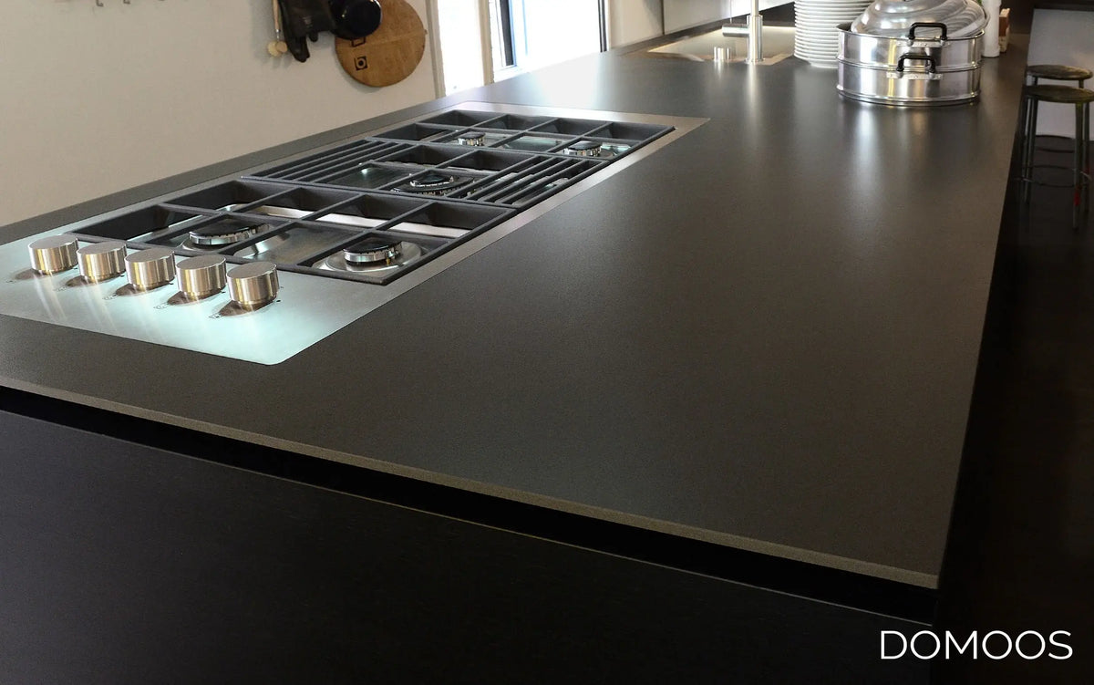 Sleek black glass kitchen countertop with integrated gas hob, modern luxury design