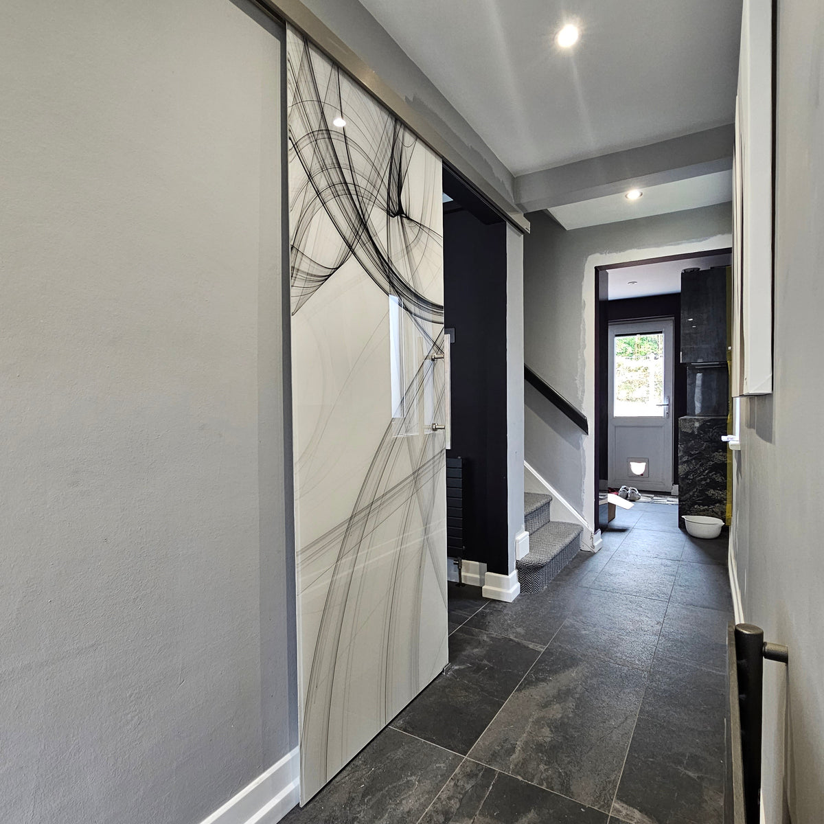 Bespoke decorative glass sliding door with abstract line art in modern hallway, featuring luxury residential design