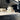 Bespoke black kitchen cabinets with LED-lit feature mirror backsplash and modern hardware