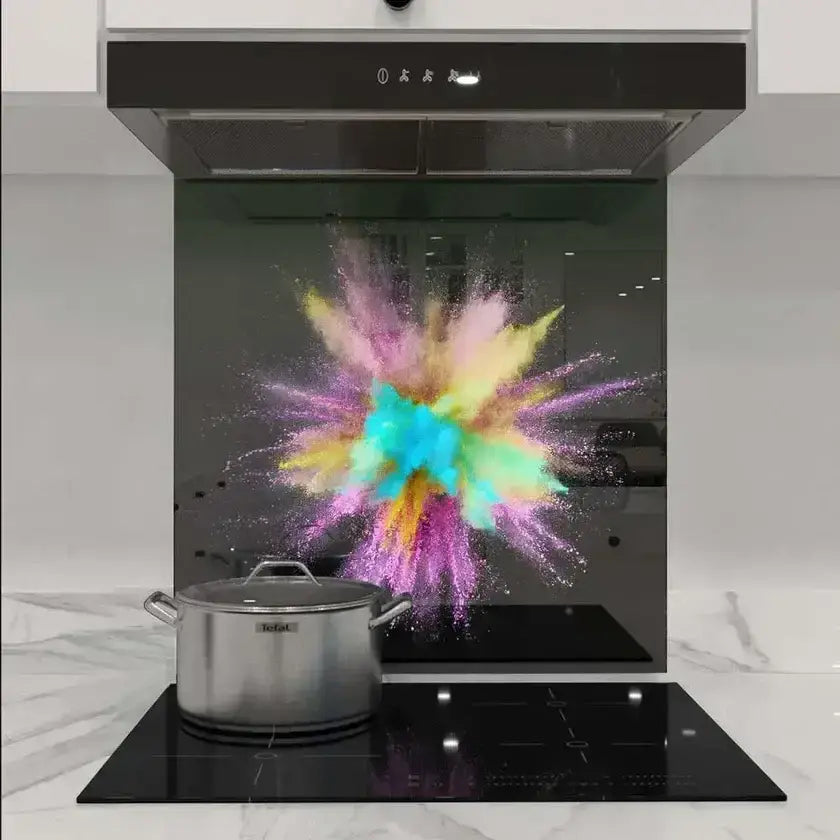 Colorful powder explosion printed on modern kitchen glass splashback behind induction hob