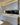 Modern kitchen with sleek white cabinets, LED-lit countertop, and black marble-effect glass backsplash