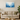 Modern living room with beige sofa, wooden round coffee table, abstract blue watercolor wall art