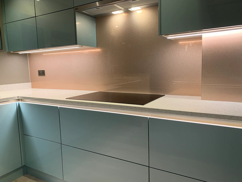 modern kitchen with sleek light blue cabinets, white quartz countertop, and glass backsplash with built-in stove
