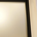 Close-up of a white hinged door with a black frame and beige wall corner in a home interior