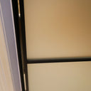 Close-up of hinged frosted glass door with black metal frame in interior setting