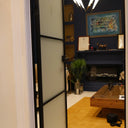 Modern interior with frosted glass hinged door, blue wall, yellow rug, wooden coffee table, and chandelier