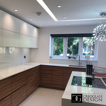 Modern kitchen with white cabinets, glass backsplash, and a chandelier.