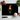 Black chopping board with a black pug wearing an orange and black striped witch hat, surrounded by kitchen items