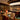 A luxury bar and lounge interior with a curved bar counter, illuminated liquor shelves, upholstered bar stools, round tables, and warm ambient lighting.