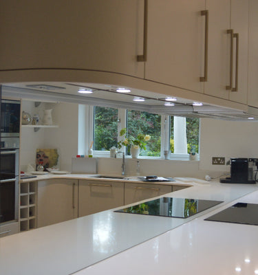 Modern kitchen with white cabinets, marble countertop, and stainless steel appliances.