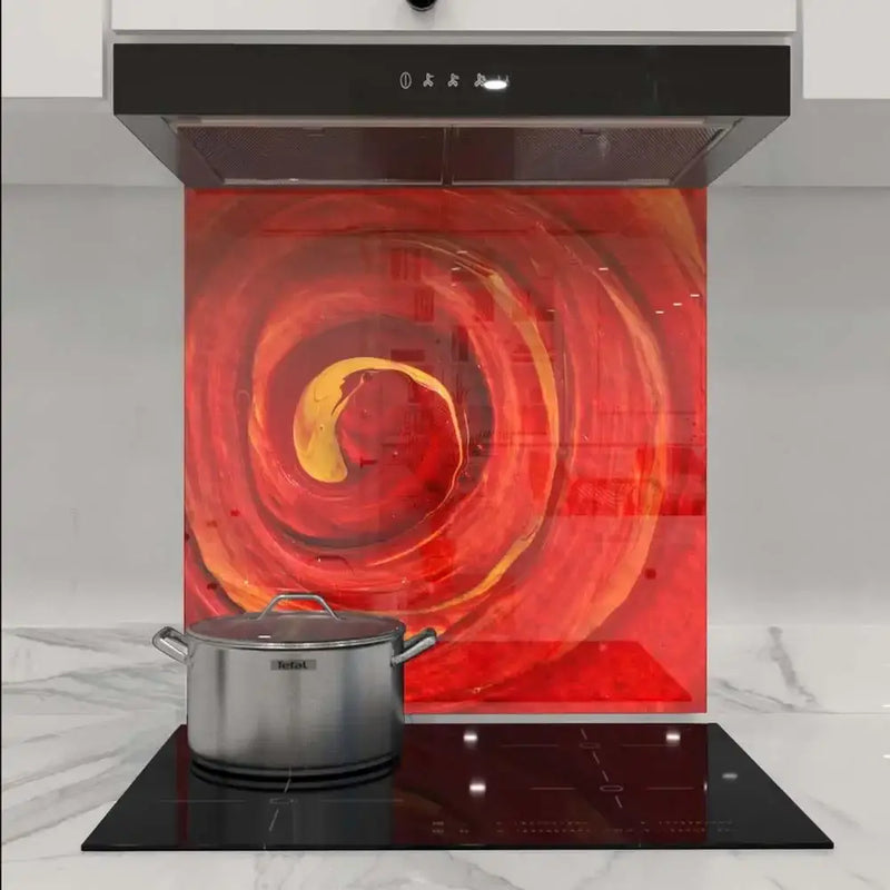 Vibrant red and gold swirl decorative glass splashback in modern kitchen with induction hob