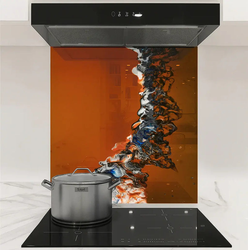 Modern kitchen stovetop with stainless steel pot and abstract orange-black glass backsplash panel