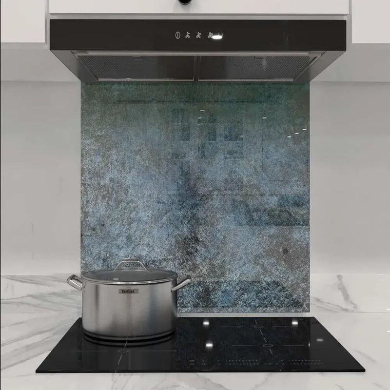 Textured blue-green decorative glass kitchen splashback behind induction hob and extractor hood
