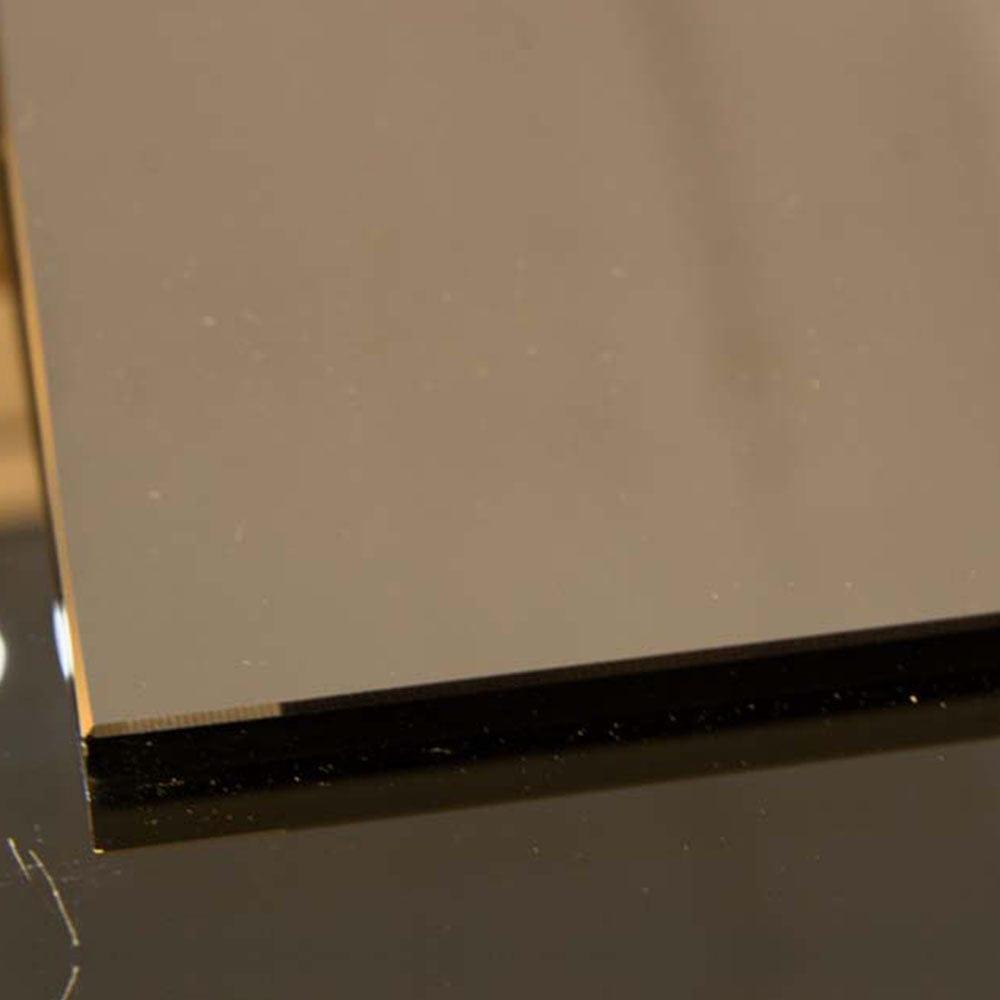 Close-up of sleek, polished glass edge with black backing, ideal for modern architectural glass installations.